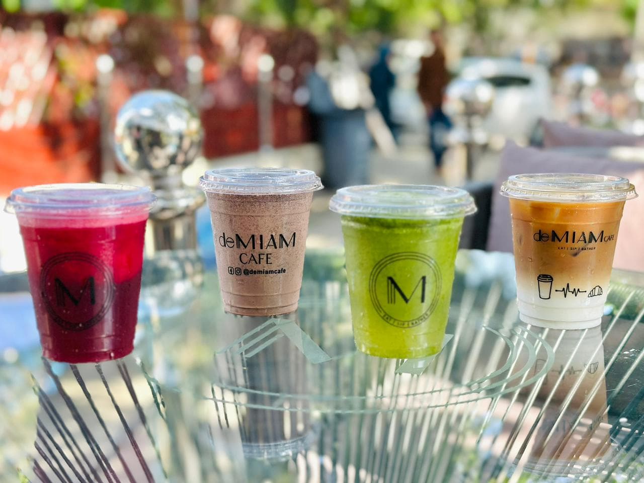 deMIAM CAFE branded cups and beverages